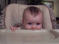 Andrew with his mouth on highchair tray