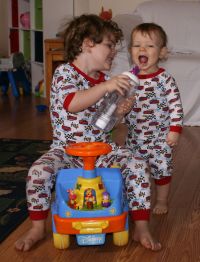 Mark helping Andrew drink water in matching pajamas