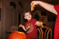 Mark shying away from the pumpkin insides that Mommy is holding
