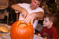 Daddy carving the pumpkin while Mark watches