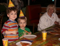 Mark and Adam eating pizza with Nana looking on